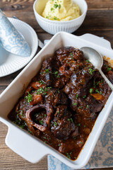 Sunday meat dish with braised beef, gravy and mashed potatoes on wooden table