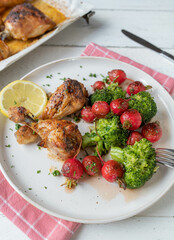 Warm salad with red radish and broccoli. Served with baked chicken on a plate
