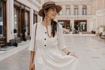 Obraz premium attractive woman walking in shopping street in Italy on vacation dressed in white summer fashion dress