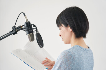 スタジオでアフレコをする女性の声優