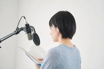 スタジオでアフレコをする女性の声優