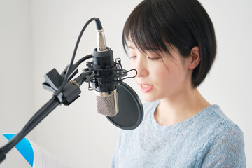スタジオでアフレコをする女性の声優