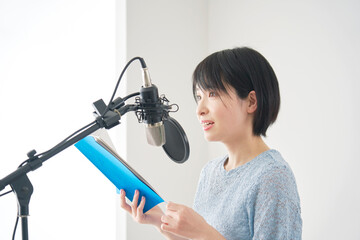 スタジオでアフレコをする女性の声優