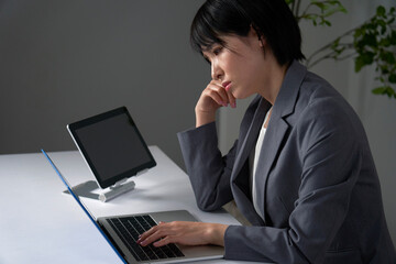 オフィスで残業して疲れているビジネスウーマン