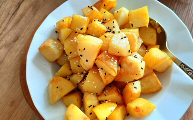 Fried potatoes sprinkled with white and black sesame seeds
