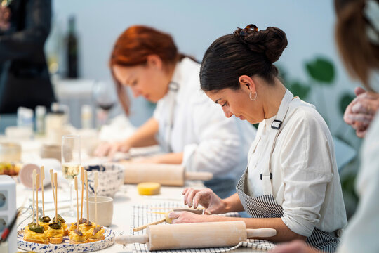 Focused women making clay products during class in studio