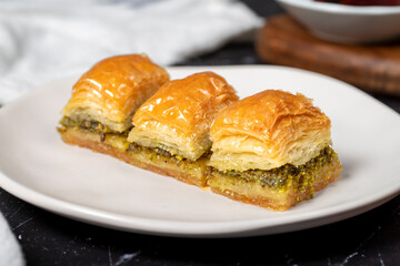 Pistachio baklava. Pistachio baklava with syrup on a dark background. Turkish cuisine delicacies. Close up