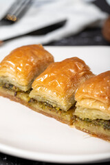 Pistachio baklava. Pistachio baklava with syrup on a dark background. Turkish cuisine delicacies. Close up