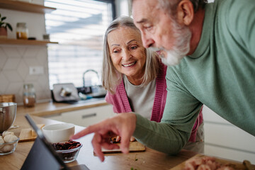 Senior couple cooking together in their kitchen.