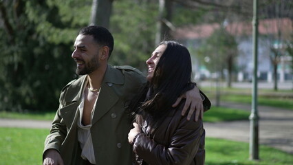 Happy Arab Couple Enjoying Sunny Stroll at Park with Genuine Laughter and Smiles
