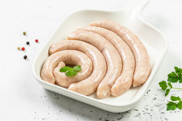 Fresh turkey sausages on white plate. Top view, copy space.