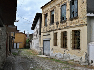 Fototapeta na wymiar old abandoned building with broken windows in a small street in europe (old, historic) albania elbasan