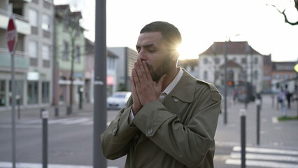 Fototapeta premium Frustrated young man walking in city street feeling disbelief. One Male Middle Eastern person walks in sidewalk suffering from regret and anxiety