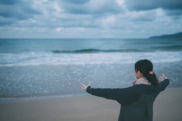 ろうの女性が海で日本の手話で大きいと表している