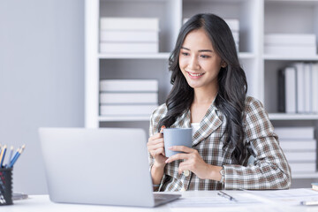 Portrait of Asian business woman holding coffee cup with work in workplace office Business documents money financial planning concept