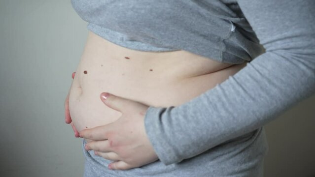 Close-up of fat folds on the large belly of an overweight woman. Concept of overweight, female obesity, dieting and overweight problems.