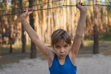 Fototapeta premium Cute cheerful boy near volleyball net. Healthy lifestyle of adolescents
