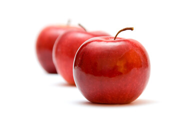 three red apples against white background