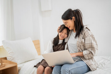 Asian Mother Teaching Children Online Learning on Laptop in white room of Home Happy Smile