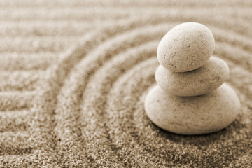 Fototapeta na wymiar Macro of three staked stones on raked sand **Note: Shallow depth of field