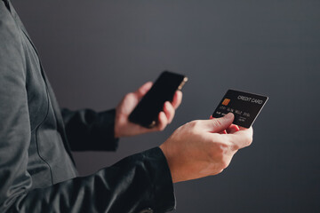 businessman showing a mock-up credit card for business and shopping to make payment and smartphone.half body. purchase, commerce, financial, card, money, using technology. selective focus.