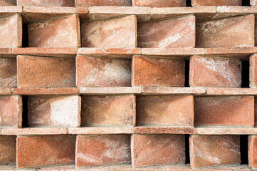 Volumetric background of narrow red bricks, laid out in levels at different angles to each other