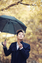 Autumn rainy weather and a young man with an umbrella