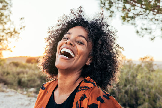 Cheerful black woman laughing in countryside