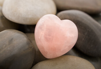 Fototapeta premium Rose quartz heart on pebbles