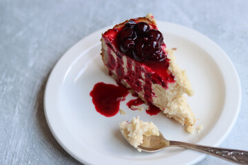 Cheesecake with cherry jam on the table. Close up photo of sweet cake