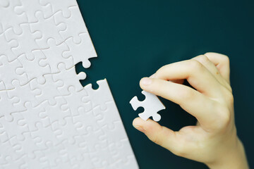 Intellectual puzzles. The puzzle is empty. The hand puts together puzzle pieces. Brain training.