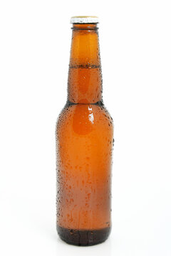 Chilled brown beer bottle over white background
