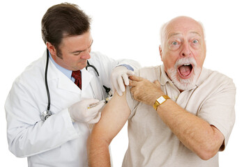 Senior man at the doctor's office, surprised by a painful injection.  Isolated on white.