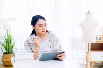 Asian woman enjoying designing clothes which is a job that she happily loves