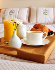 Tray with breakfast on a bed in a hotel room