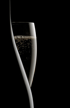 bottle and flute of champagne on black background