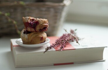 Two berry muffins on a book.