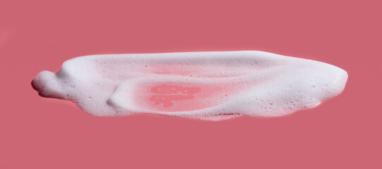 White soap foam, suds of detergent, cleaning gel or shampoo on pink backdrop
