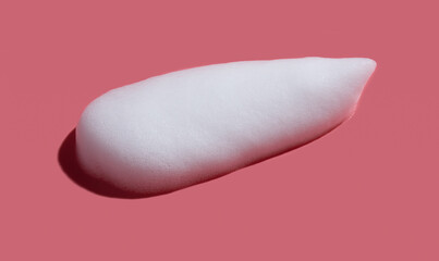 White soap foam, suds of detergent, cleaning gel or shampoo on pink backdrop