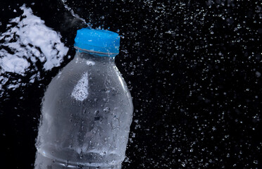 Water bottle with water splash on black background