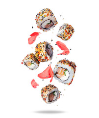 Fresh sushi rolls with ginger in the air isolated on white background