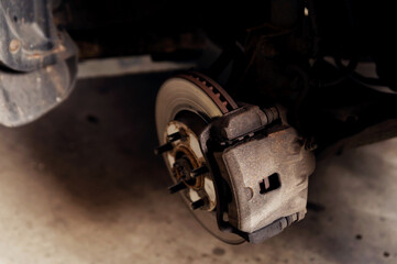 old braking system. close-up of repair. replacement brake disc and pad. car maintenance service....