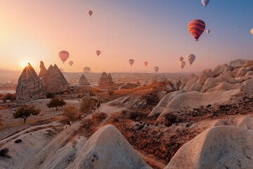 Landscape sunset in Cappadocia, travel tour excursion on horse with hot air balloons in Goreme Turkey