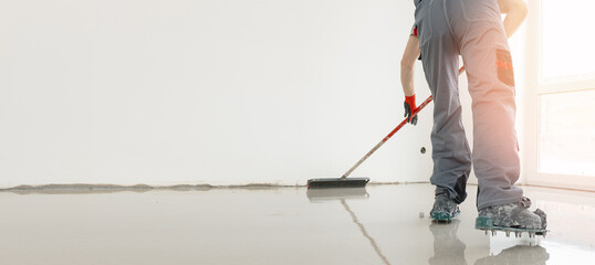 Master with needle roller for new screed concrete with mixture of cement for leveling for floors...