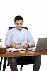 handsome businessman working on laptop and holding money