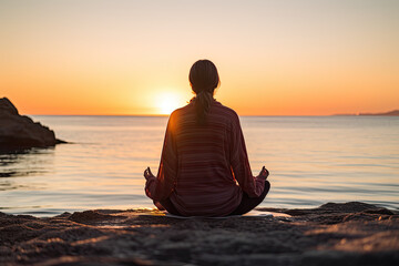 a woman meditating by the sea during sunrise