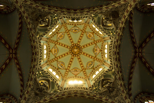 Toma en contrapicada de una b&oacute;veda con candelabros e iluminaci&oacute;n dentro de una iglesia.