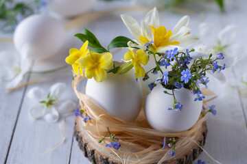 Easter eggs with spring flowers inside on wooden table.Happy easter background. Easter centerpiece.