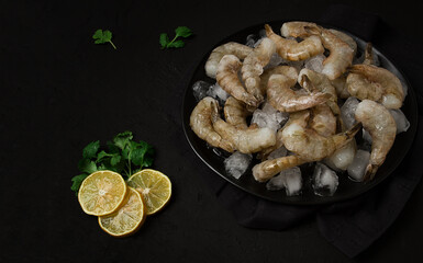 Fresh raw shrimp spread on ice with lemon and cilantro slices on a marble surface, ready to cook, no people