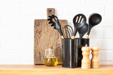Kitchen utensils. Cooking tools with wooden cutting boards, oil and shaker at white modern kitchen...